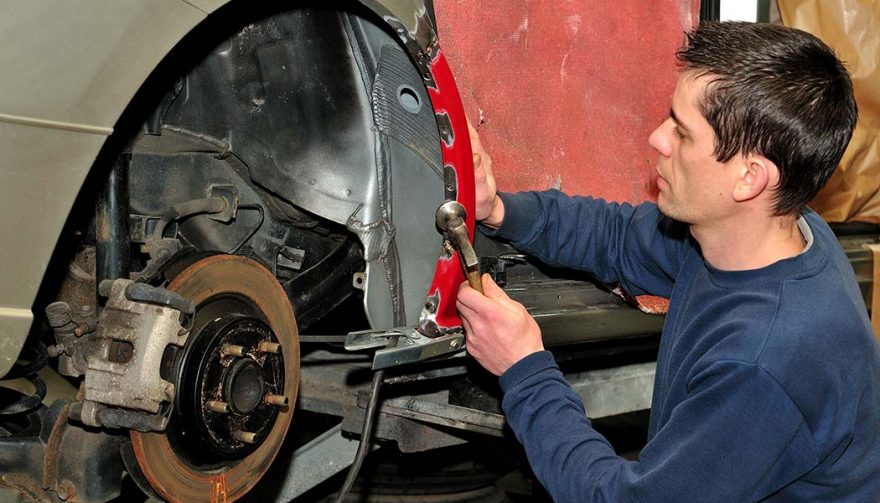 A man is keeping safe working on a car