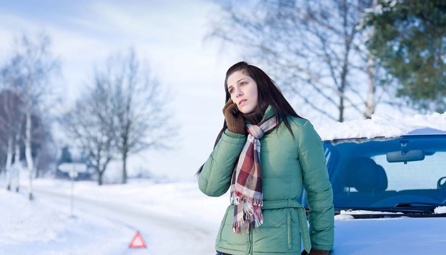 A woman's car in winter is broken down