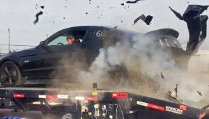 A tire explodes on a dyno, causing extensive damage to the rear of the car