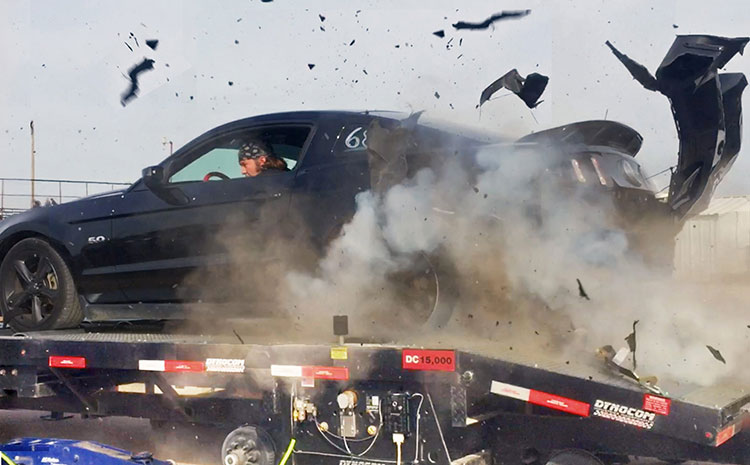 A tire explodes on a dyno, causing extensive damage to the rear of the car