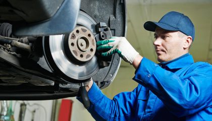 A mechanic begins brake repair work on new disc pads