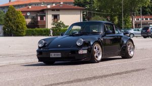 An air-cooled 911 driving down the road.