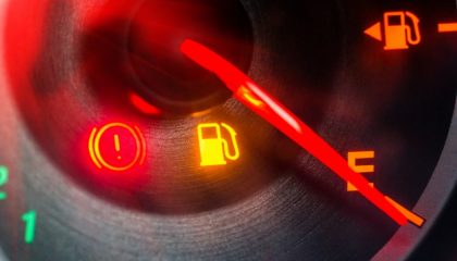 A low fuel light on a dashboard indicates the gas tank is low