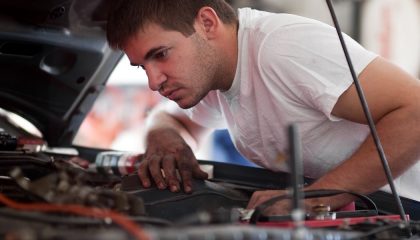 A man performs a car maintenance inspection