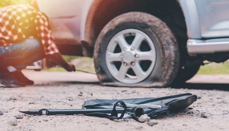 A person changing a flat tire.