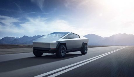 A Tesla Cybertruck riding on the road on a sunny day.